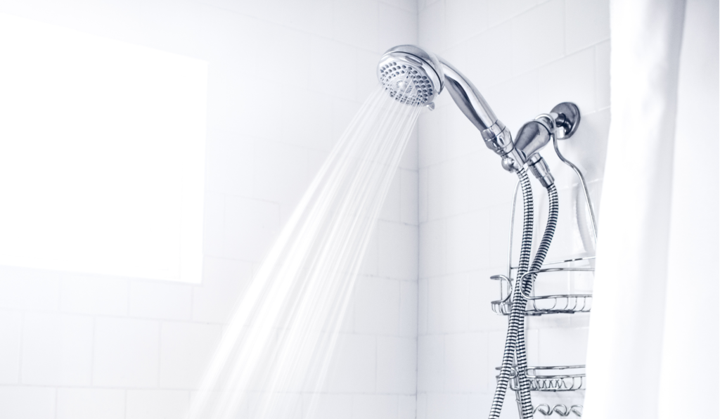Shower head spraying hot water powered by an energy-efficient propane water heater in a modern bathroom